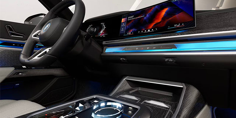 A sleek 2025 BMW i7 interior featuring a modern dashboard, large display screen, and illuminated controls.