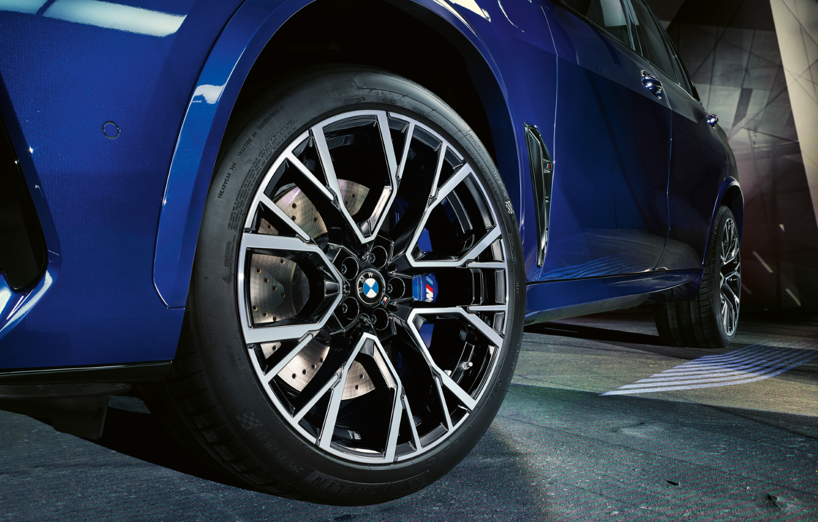 BMW Service Technician in service bay inspecting a BMW on a lift